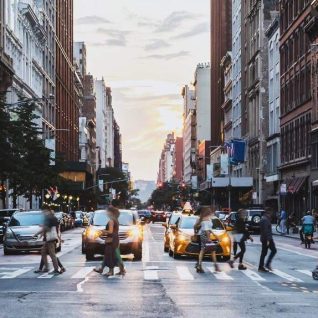 City street with pedestrians crossing, demonstrating Safe Strets For All grant program